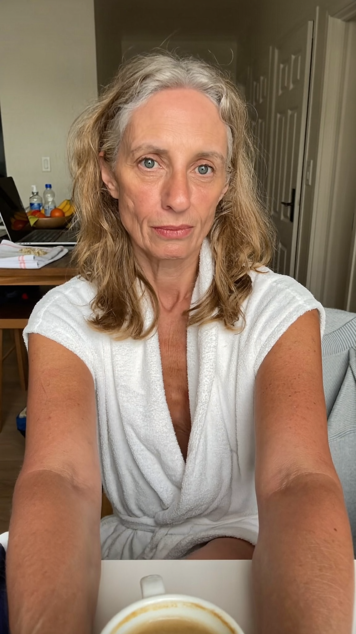 Woman in her 50s wearing sleeveless clothing for the first time since her GLP-1 weight loss, candid moment, arms in sunlight